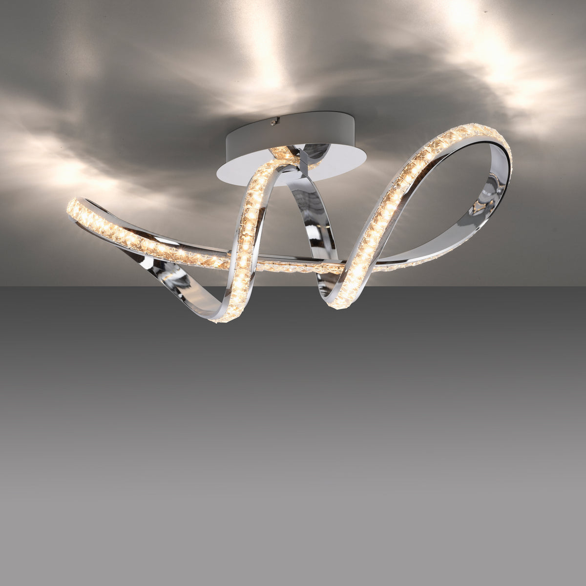 Plafonnier allumé au plafond gris, diffusant une lumière chaude et des motifs.