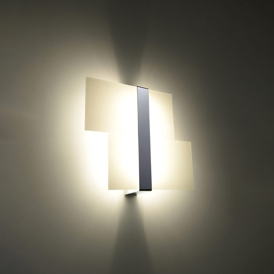 Vue de l'applique murale allumée dans une pièce sombre, éclairage chaud et halos.