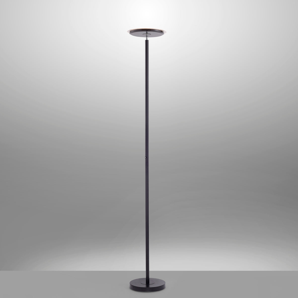 Lampadaire allumé éclairant le plafond, halo lumineux sur fond gris.