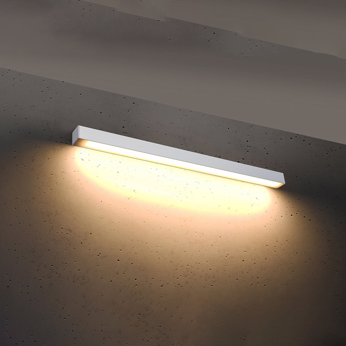 Mise en ambiance nocturne, halo lumineux chaud projeté sur le béton