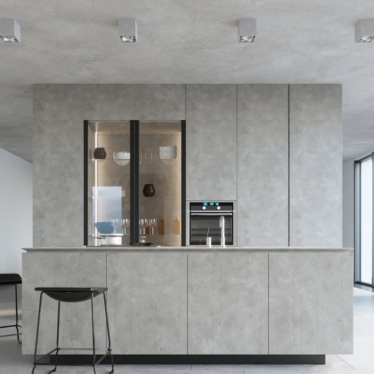 Mise en ambiance cuisine béton avec quatre spots plafonniers alignés au-dessus de l'îlot