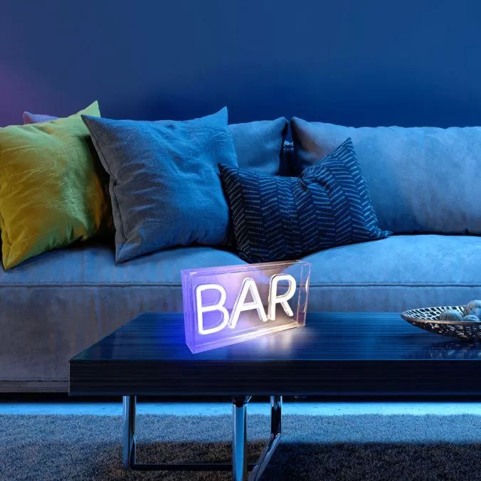 Mise en ambiance sur une table basse devant un canapé bleu garni de coussins
