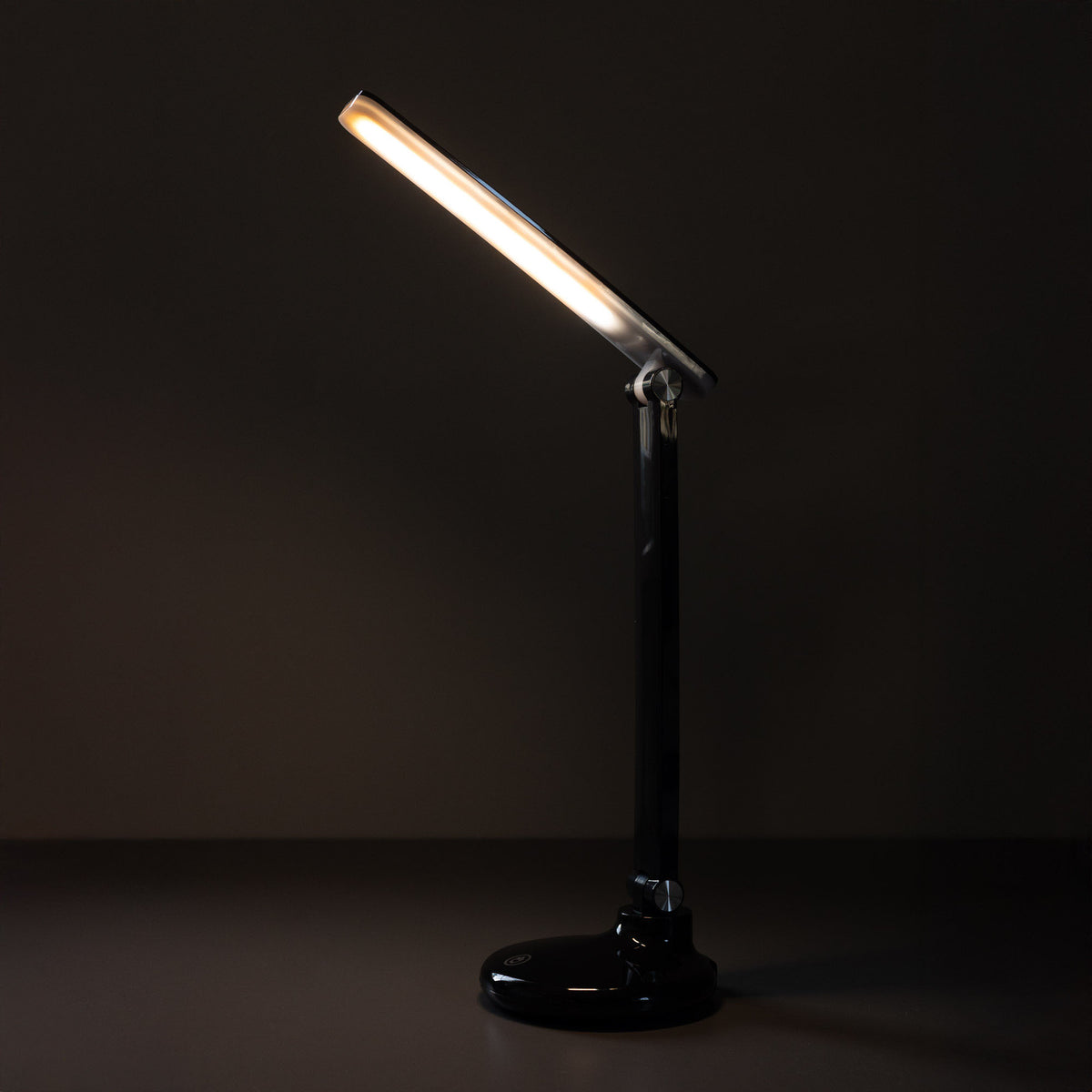 Mise en ambiance sombre, la lampe allumée souligne le bras brillant