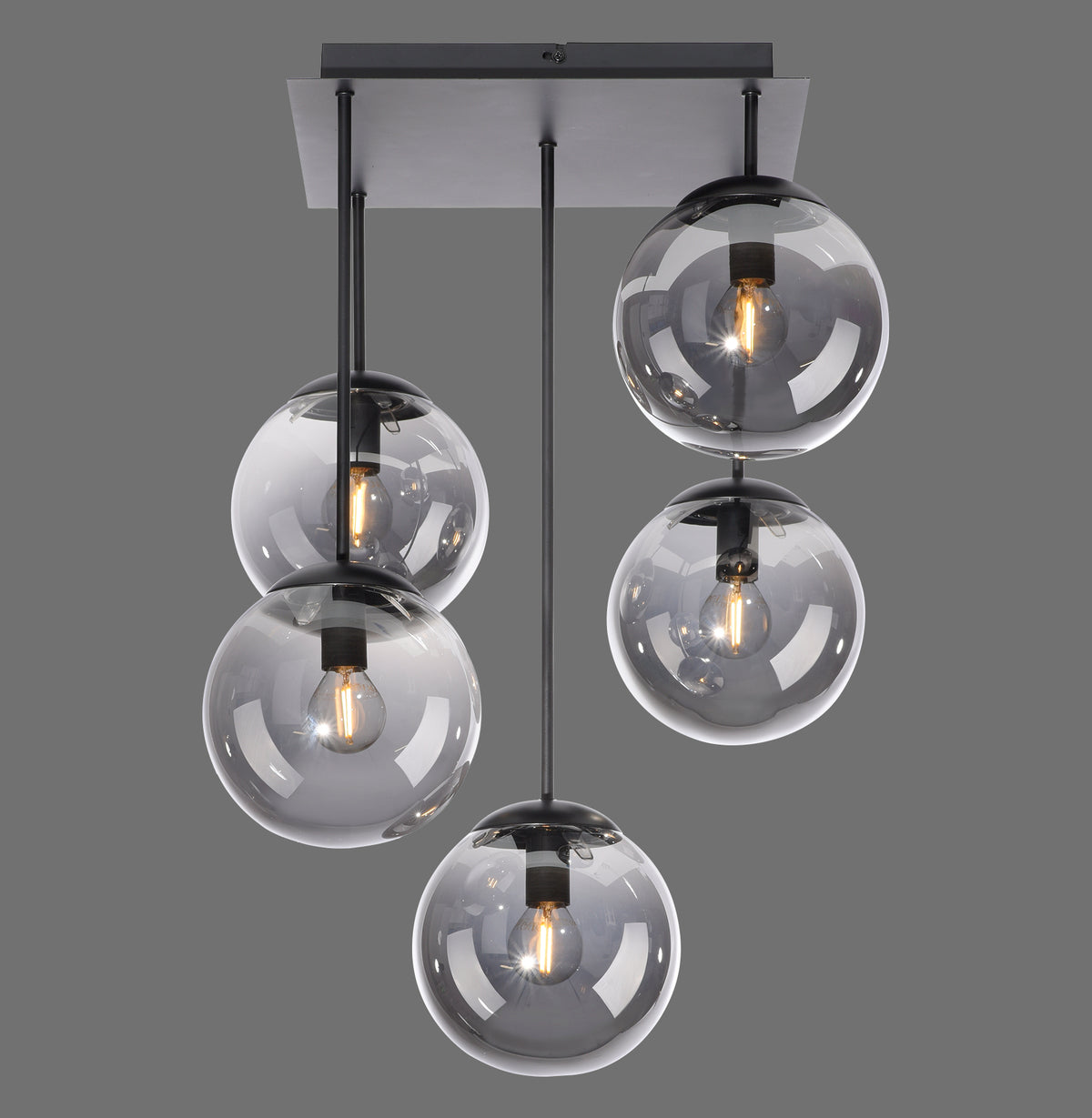 Plafonnier cinq globes de verre fumé suspendus à des tiges noires sur fond gris