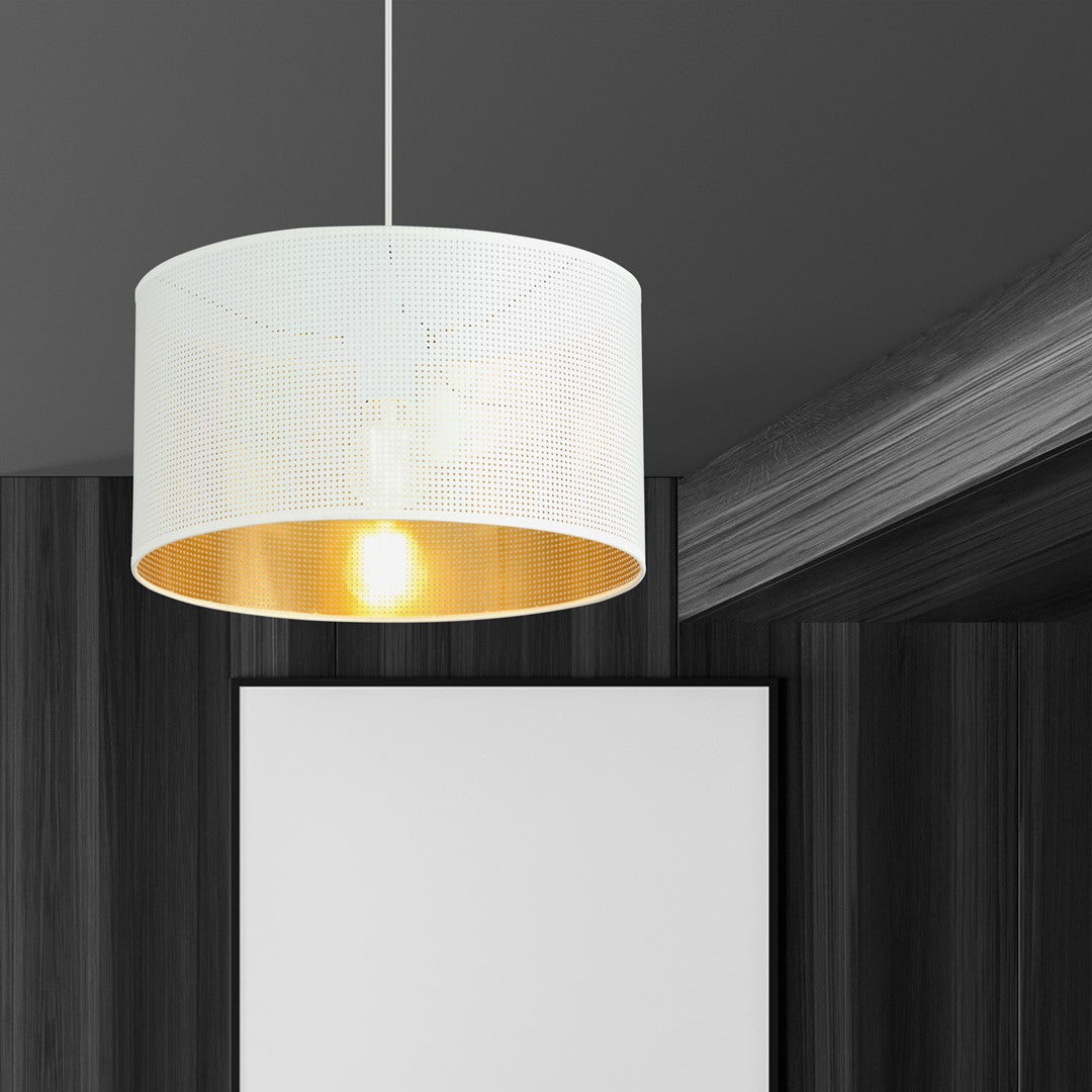 Suspension blanche et dorée allumée dans un intérieur sombre, au-dessus d'un panneau blanc