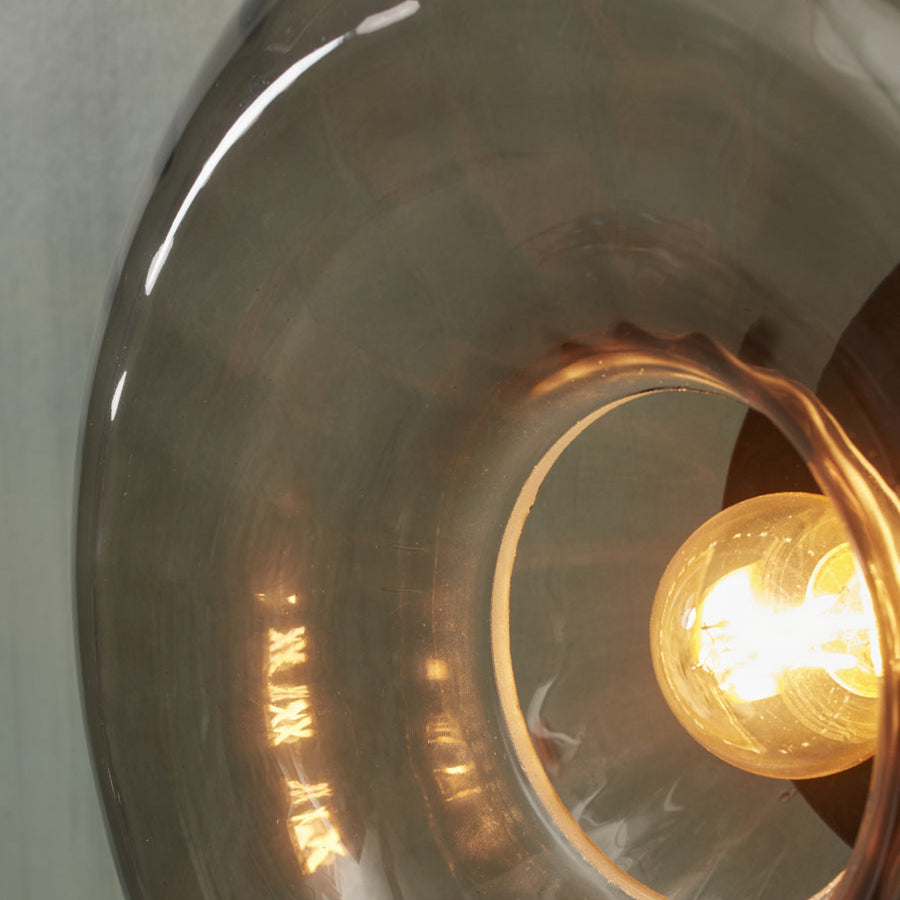 Gros plan sur l’ampoule allumée et l’épaisseur du verre fumé