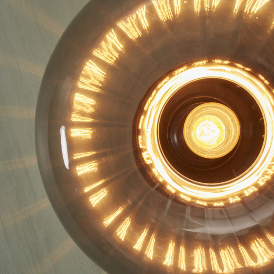 Détail rapproché du verre fumé et des reflets lumineux en éventail