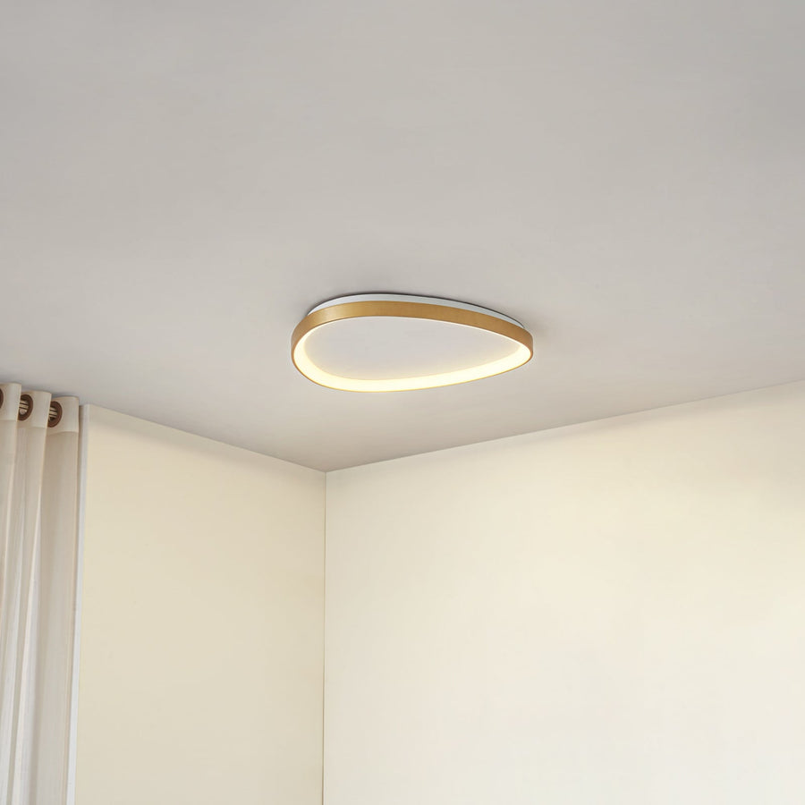 Plafonnier doré allumé au plafond, avec un rideau blanc visible sur la gauche.