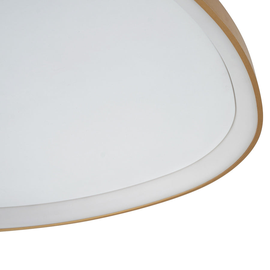 Détail du bord doré et du diffuseur blanc du plafonnier, en gros plan.