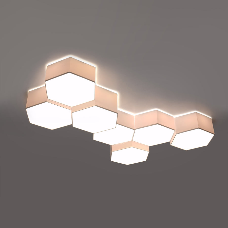 Grande composition de sept hexagones allumée, lumière chaude sur plafond gris