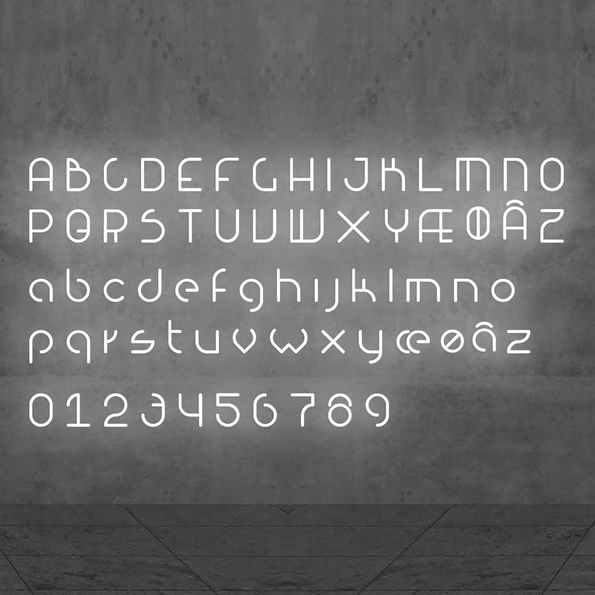 Alphabet complet lumineux présenté sur un mur gris, lettres et chiffres