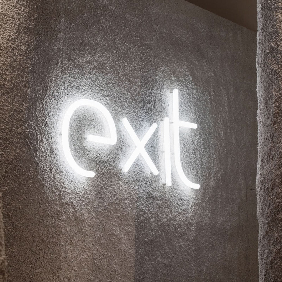 Détail du mot exit en lettres lumineuses sur un mur texturé