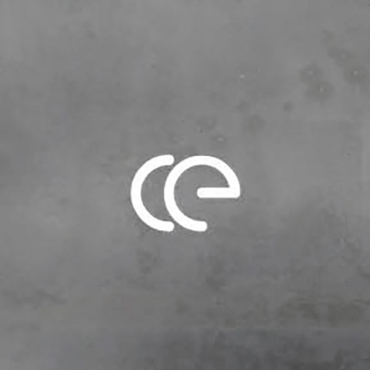 Détail rapproché de deux lettres blanches lumineuses formant « ce » sur un mur gris.