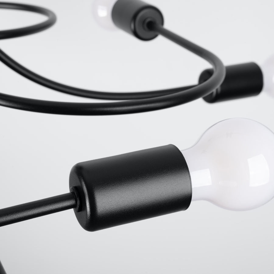 Gros plan sur une douille noire cylindrique et son ampoule blanche, finition mate.