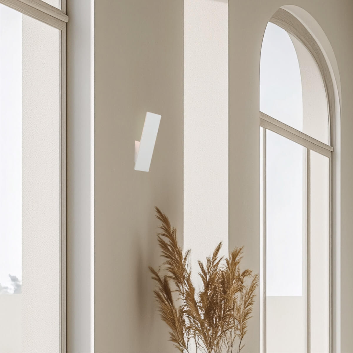 Vue rapprochée de l'applique murale blanche sur un mur beige épuré