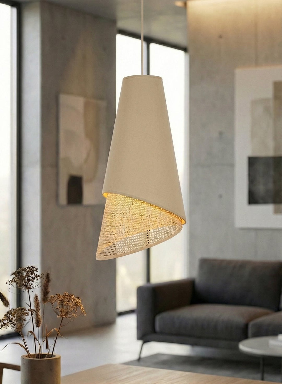 La suspension allumée dans un salon béton, lumière chaude filtrée par le rotin