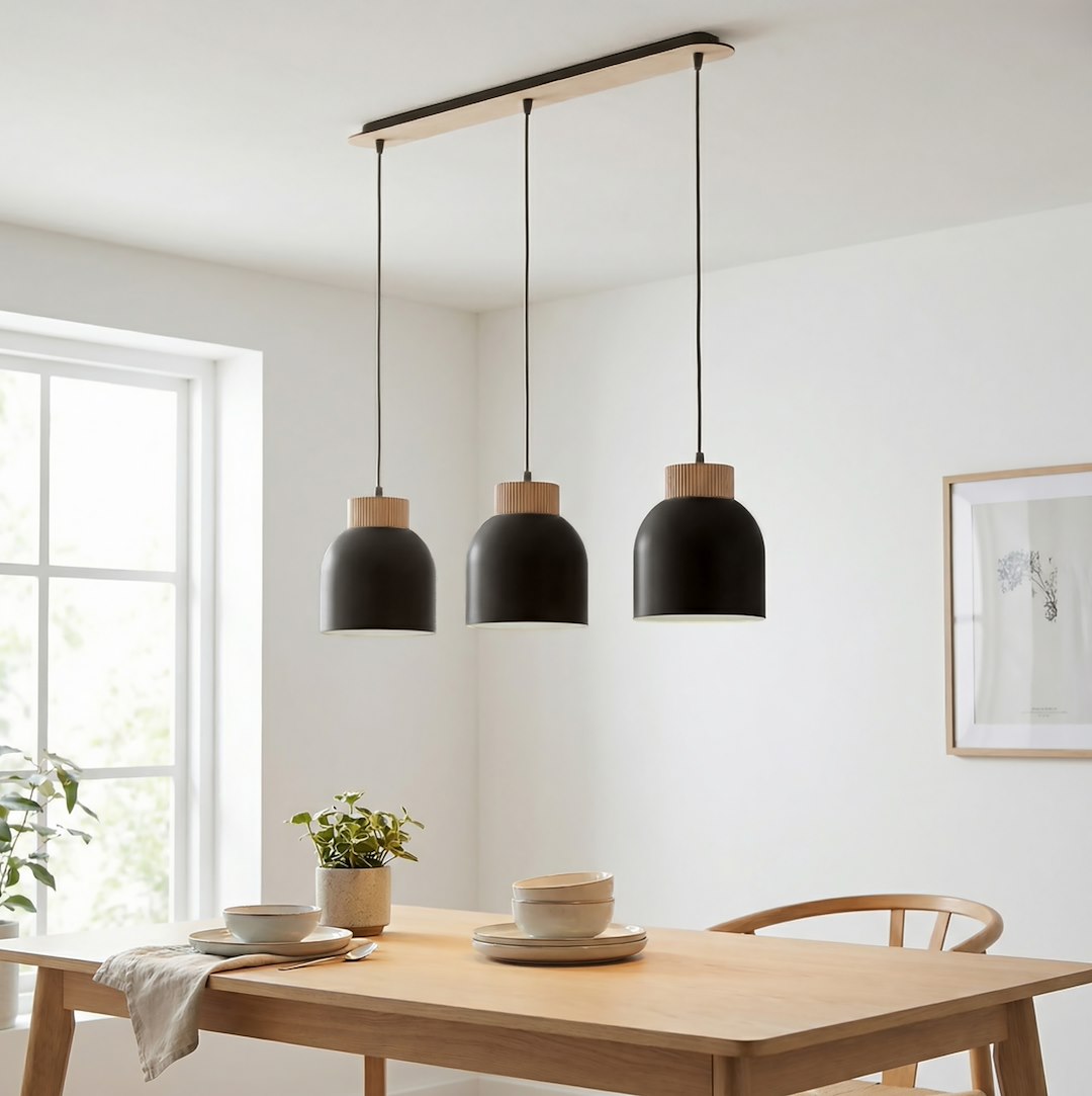 Luminaire suspendu au-dessus d'une table en bois dans une salle à manger claire