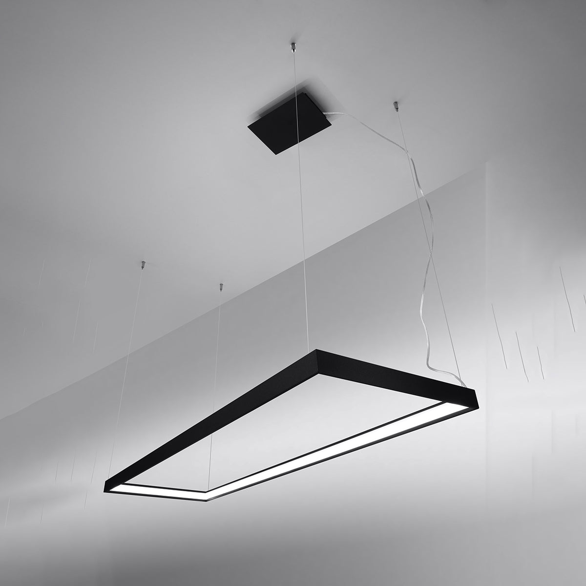 Plongée montrant le cadre rectangulaire noir suspendu sous le plafond