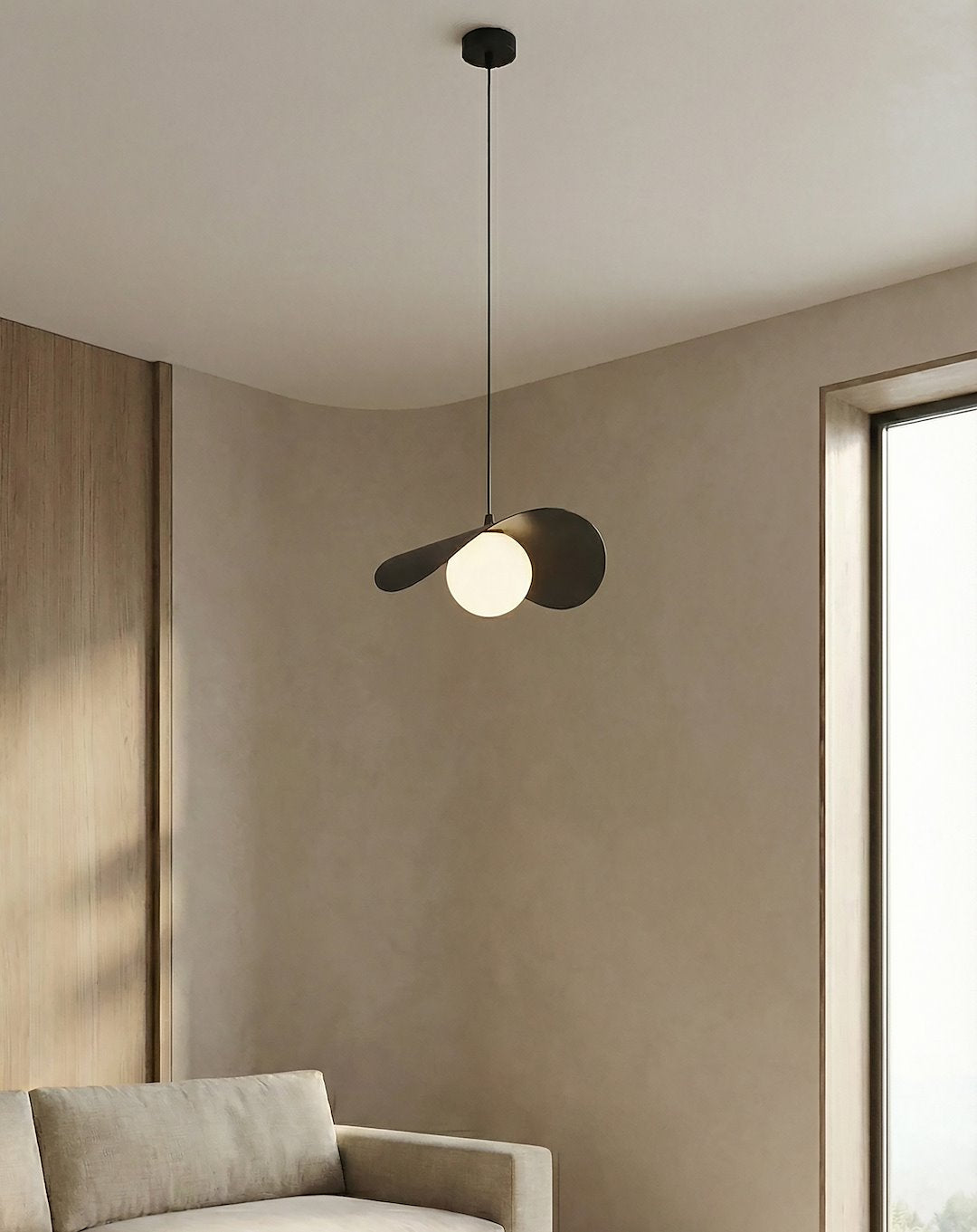 Mise en ambiance intérieure beige, suspension devant mur clair et canapé
