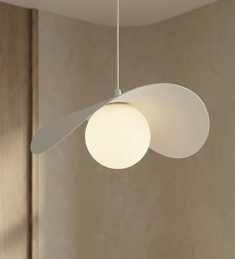 Détail rapproché du globe lumineux et des pétales blancs incurvés, suspension allumée.