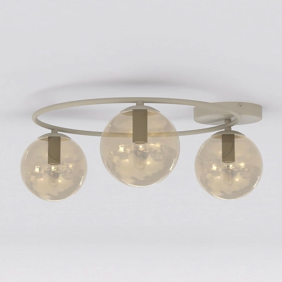 Vue rapprochée du plafonnier beige, trois globes ambrés et structure en anneau.