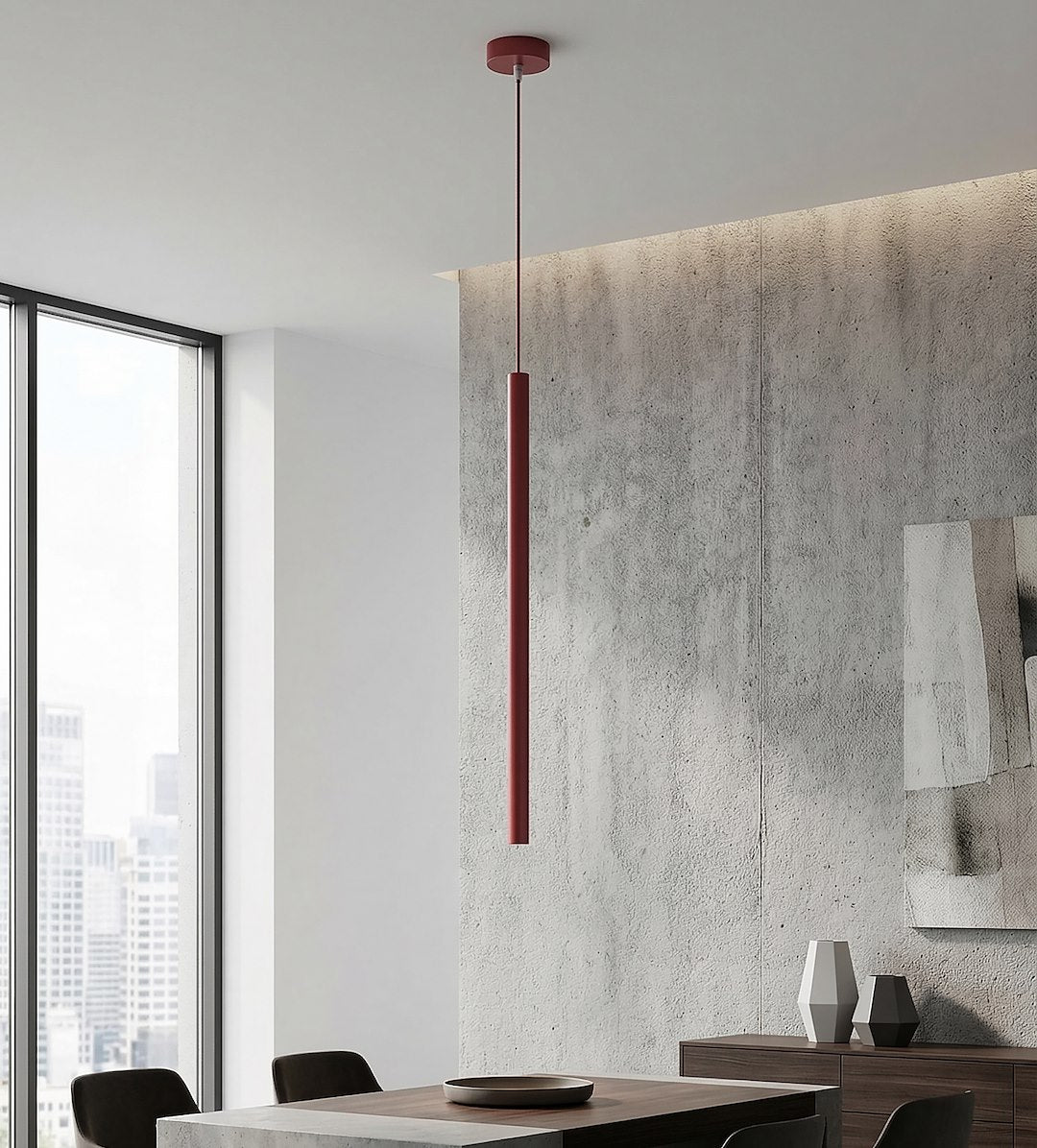 Mise en ambiance au-dessus d'une table, suspension rouge devant un mur en béton brut.