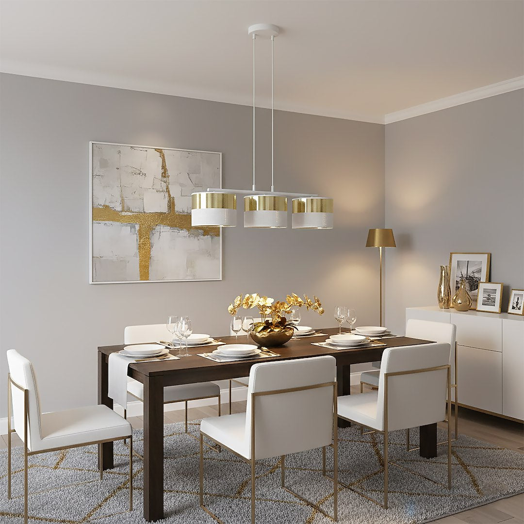 Suspension au-dessus d'une table à manger dressée, chaises blanches et décoration dorée