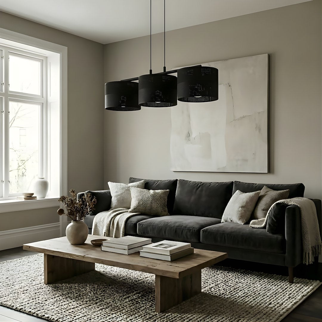 Mise en ambiance salon avec canapé gris, suspension noire au-dessus de la table basse