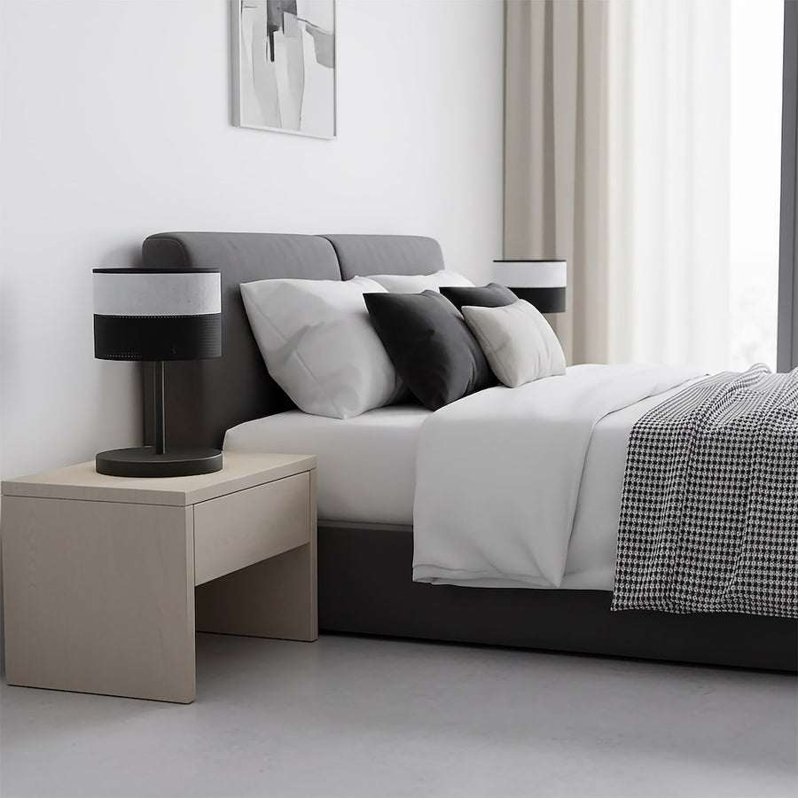 Lampe posée sur une table de chevet dans une chambre grise et blanche