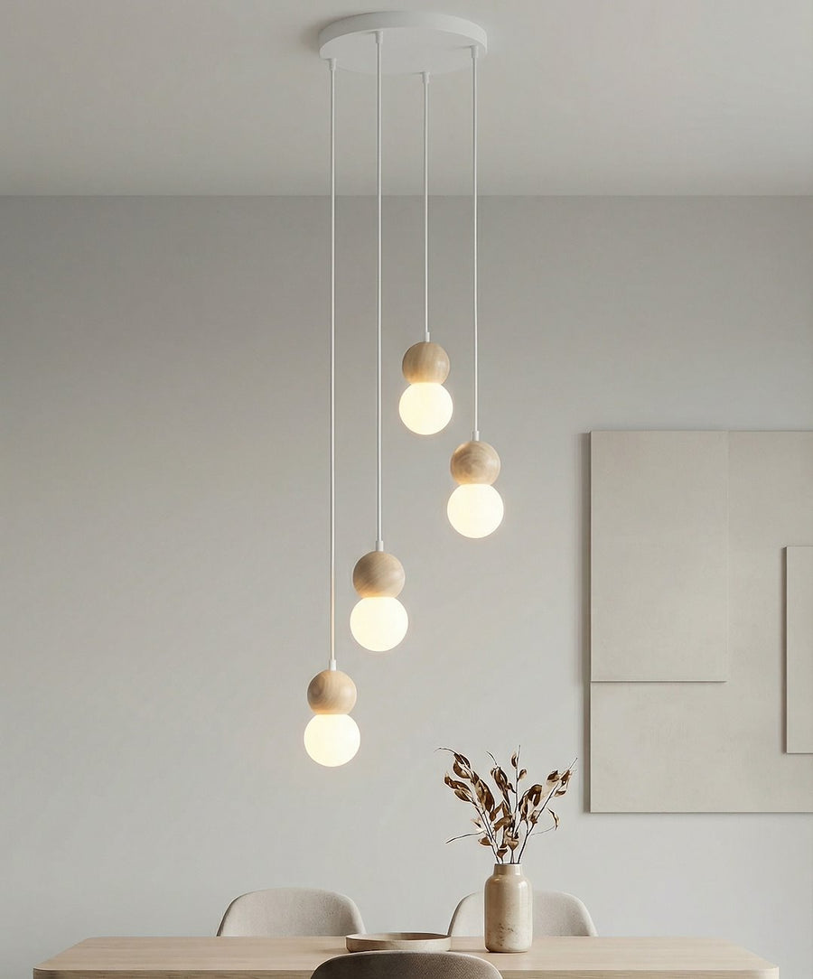 Vue rapprochée des quatre globes allumés au-dessus d'une table avec vase et branchages