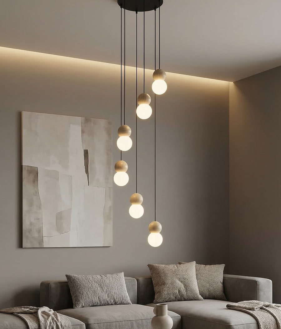 Mise en scène dans un salon, suspension allumée au-dessus d'un canapé gris