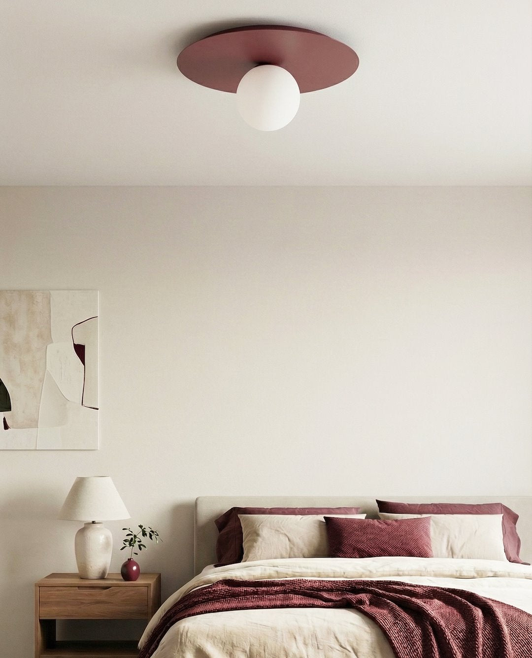 Mise en ambiance dans une chambre, plafonnier bordeaux au-dessus du lit beige