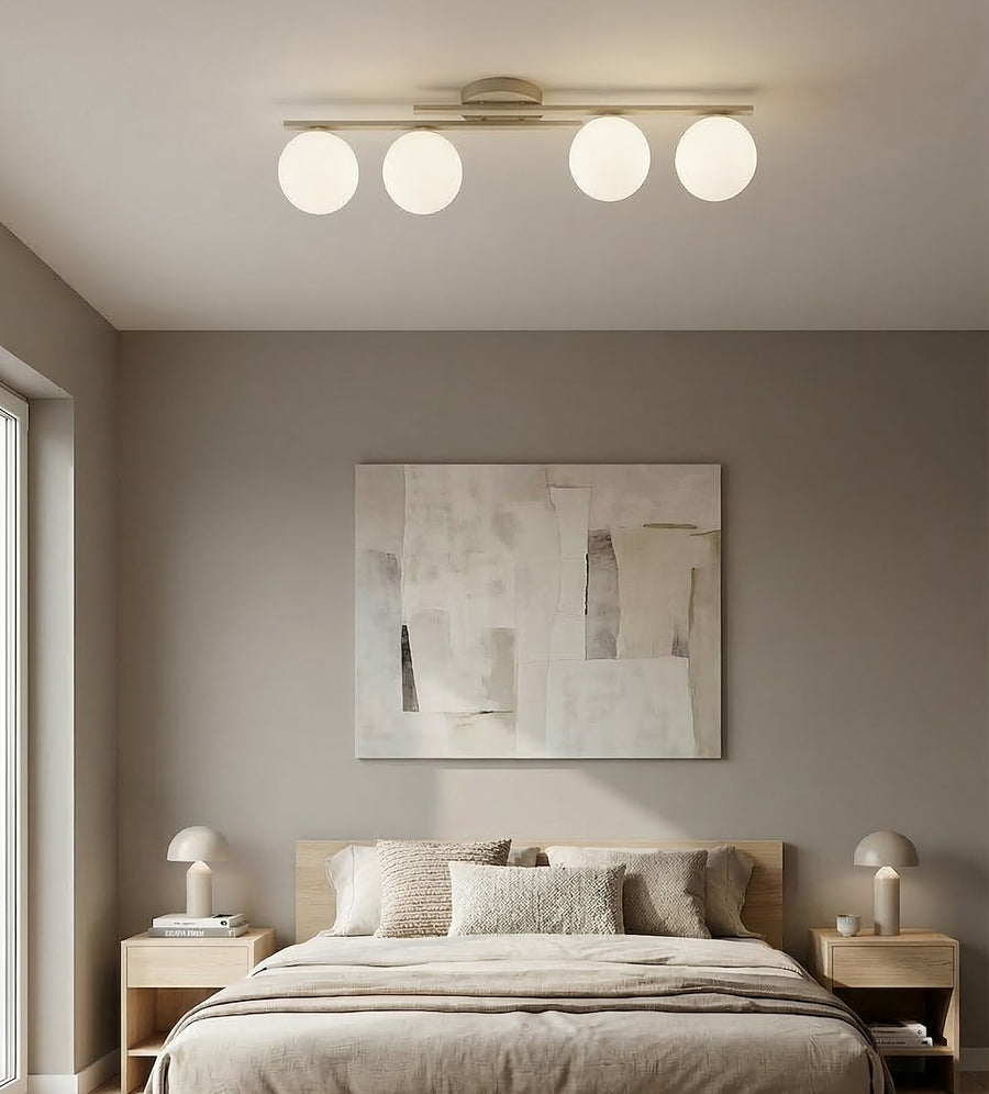Plafonnier beige allumé au plafond d'une chambre, au-dessus d'un lit garni