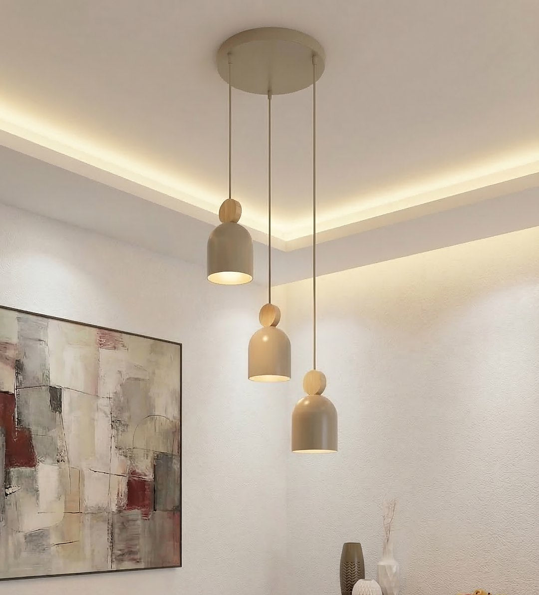 Suspension trois lumières allumée dans un salon avec moulure lumineuse au plafond