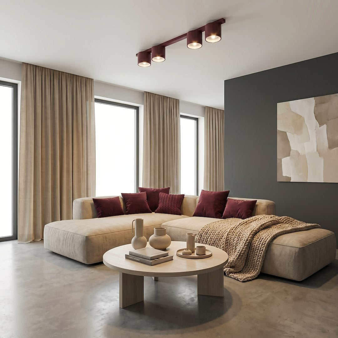 Mise en ambiance dans un salon clair, canapé beige et coussins bordeaux