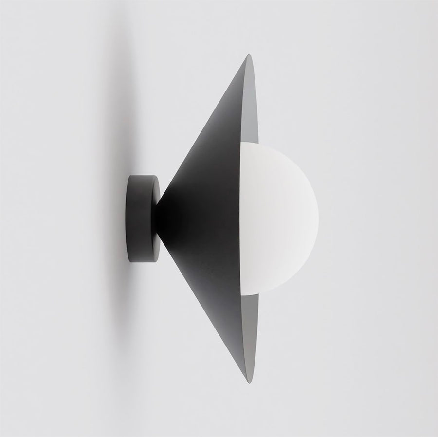 Vue de profil sur fond gris clair, applique noire au cône ouvert et diffuseur blanc.