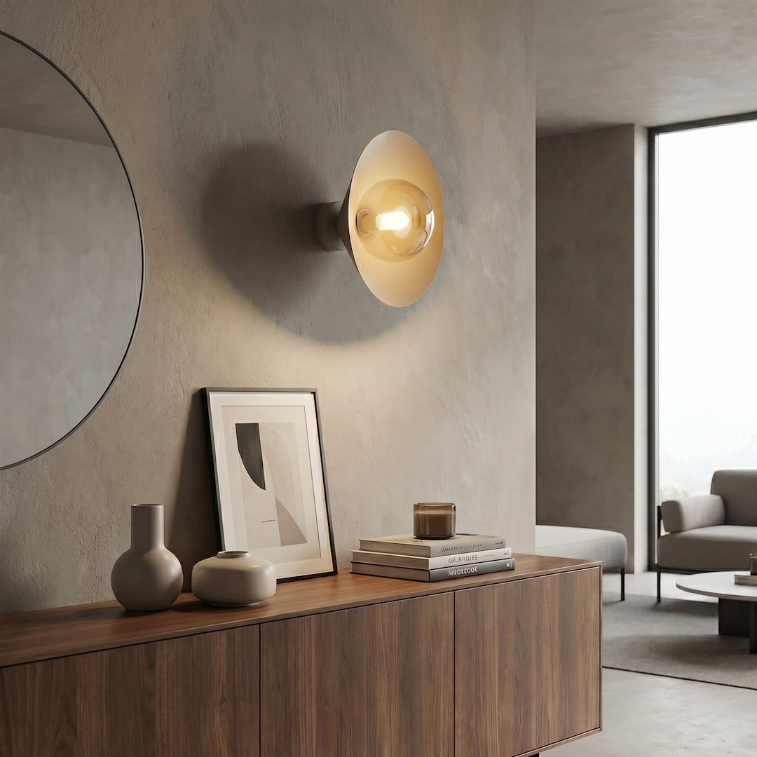 Mise en ambiance dans un salon, applique allumée au-dessus d'un meuble en bois