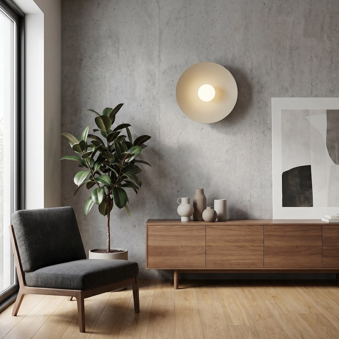 Mise en ambiance salon avec applique murale allumée au-dessus d'un meuble en bois.