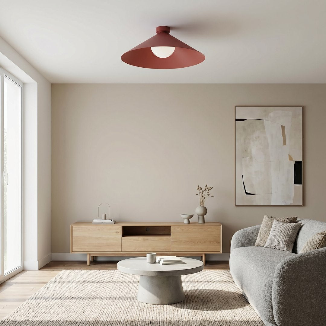 Mise en ambiance dans un salon beige, plafonnier rouge bordeaux au-dessus du canapé
