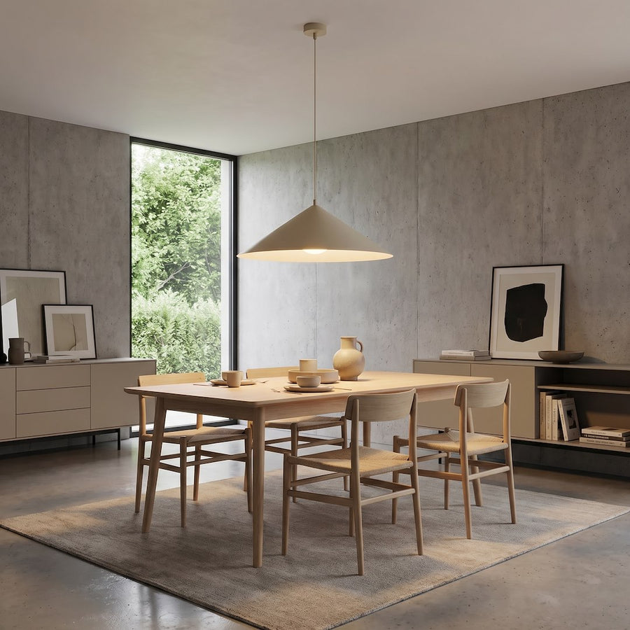 Suspension allumée éclairant une table en bois dans une pièce minimaliste