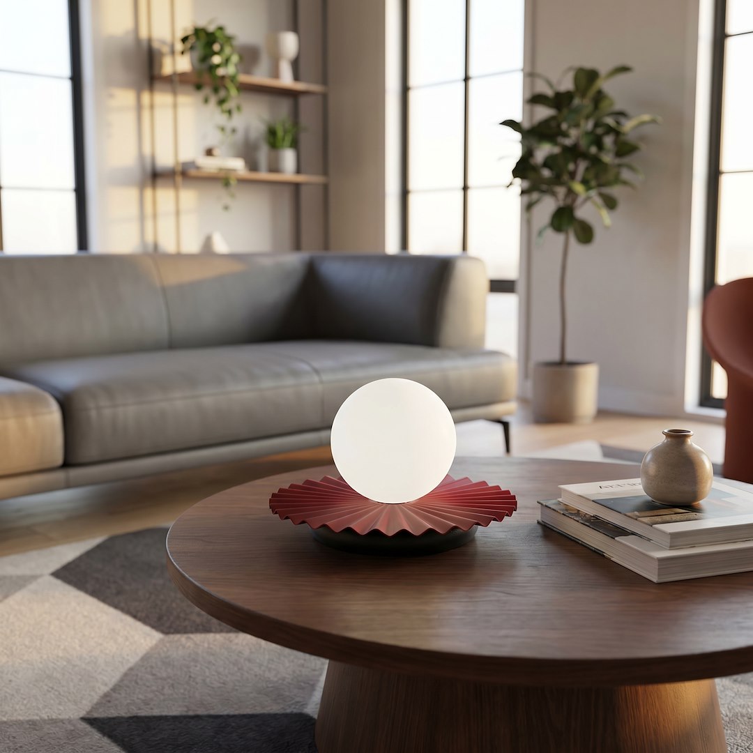 Lampe allumée sur table ronde en bois, canapé gris et fenêtres en arrière-plan