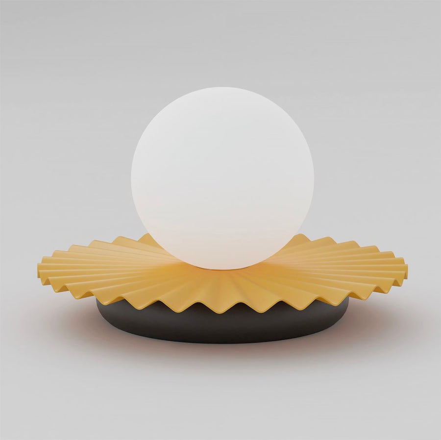 Lampe à poser de face, sphère en verre blanc sur collerette jaune plissée et socle noir