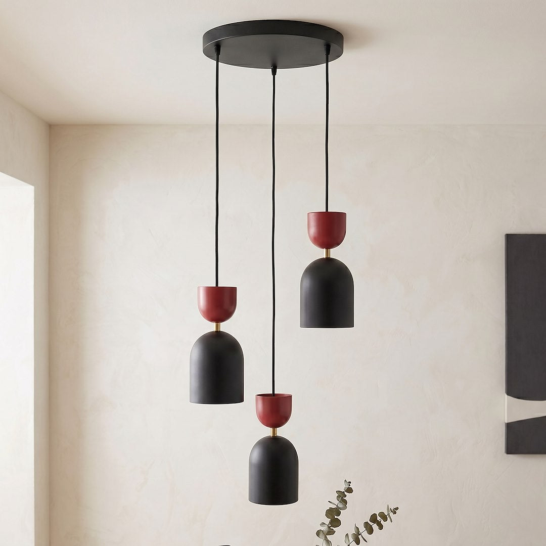 Gros plan de la suspension allumée sur fond beige, avec feuillage d'eucalyptus à droite.