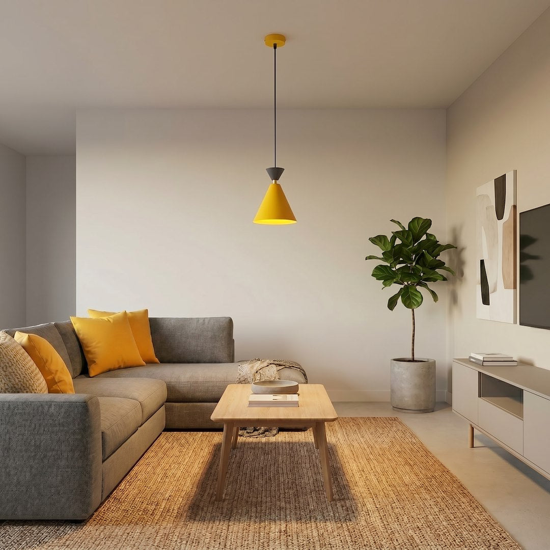 Luminaire suspendu jaune installé dans un salon gris avec canapé et tapis tissé