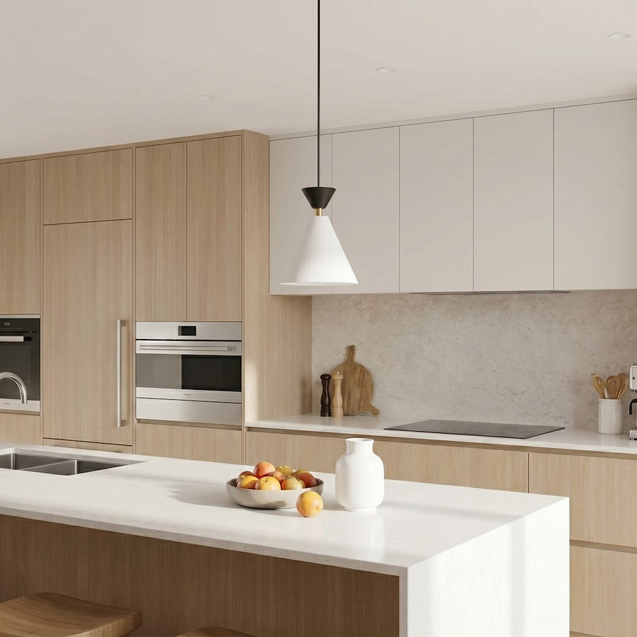 Suspension installée au-dessus d'un îlot de cuisine en bois clair et blanc.