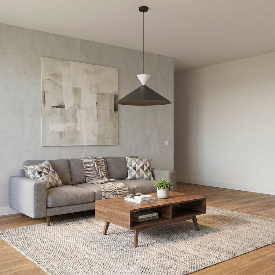 Suspension allumée éclairant un salon avec canapé gris et table basse