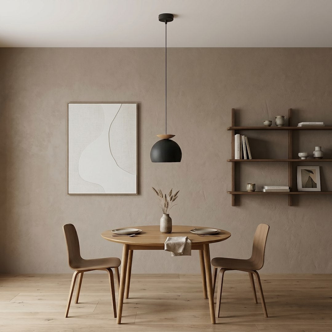 Mise en ambiance salle à manger, suspension allumée au-dessus d'une table en bois clair.
