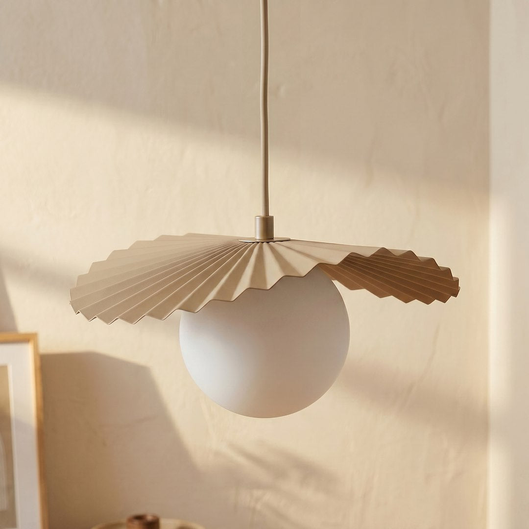 Détail rapproché d'une sphère blanche et de sa collerette beige plissée en éventail