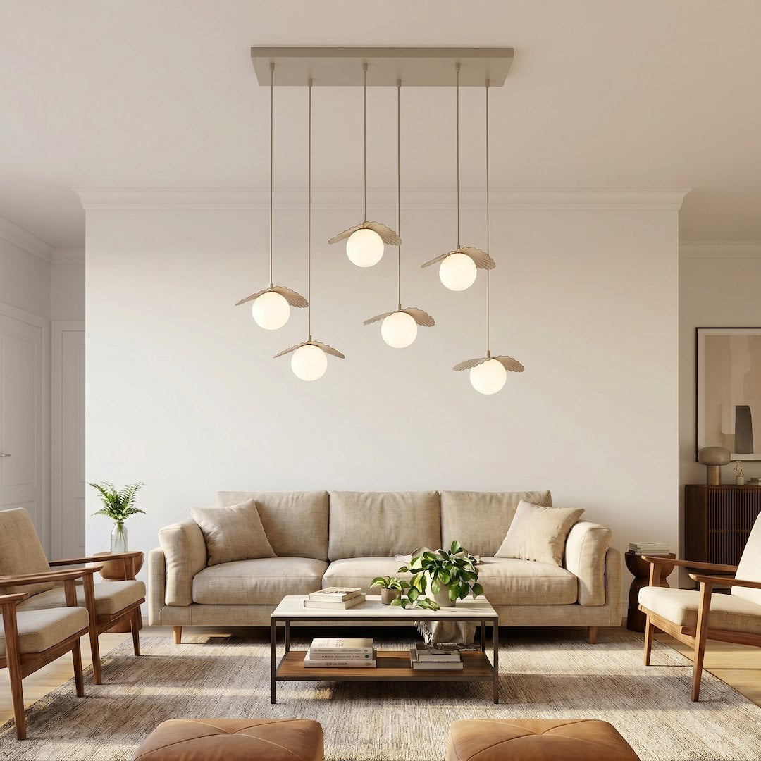 Vue d'ensemble dans un salon clair, six globes blancs suspendus devant un canapé beige