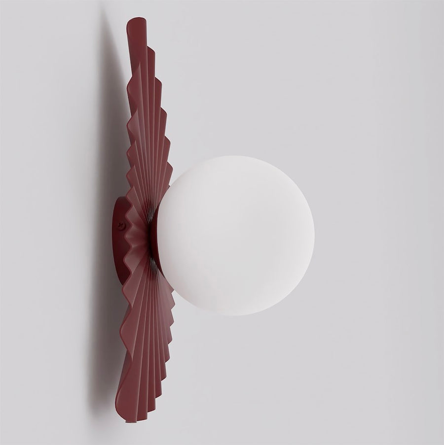 Profil de l'applique bordeaux montrant l'épaisseur du plissé et le globe blanc.